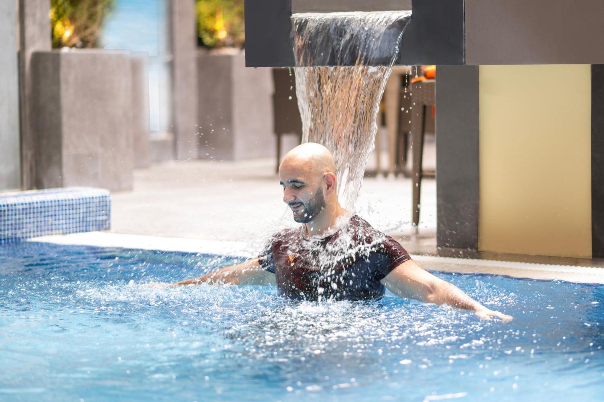 Delta Hotels By Marriott City Center Ντόχα Εξωτερικό φωτογραφία A man swimming in a pool
